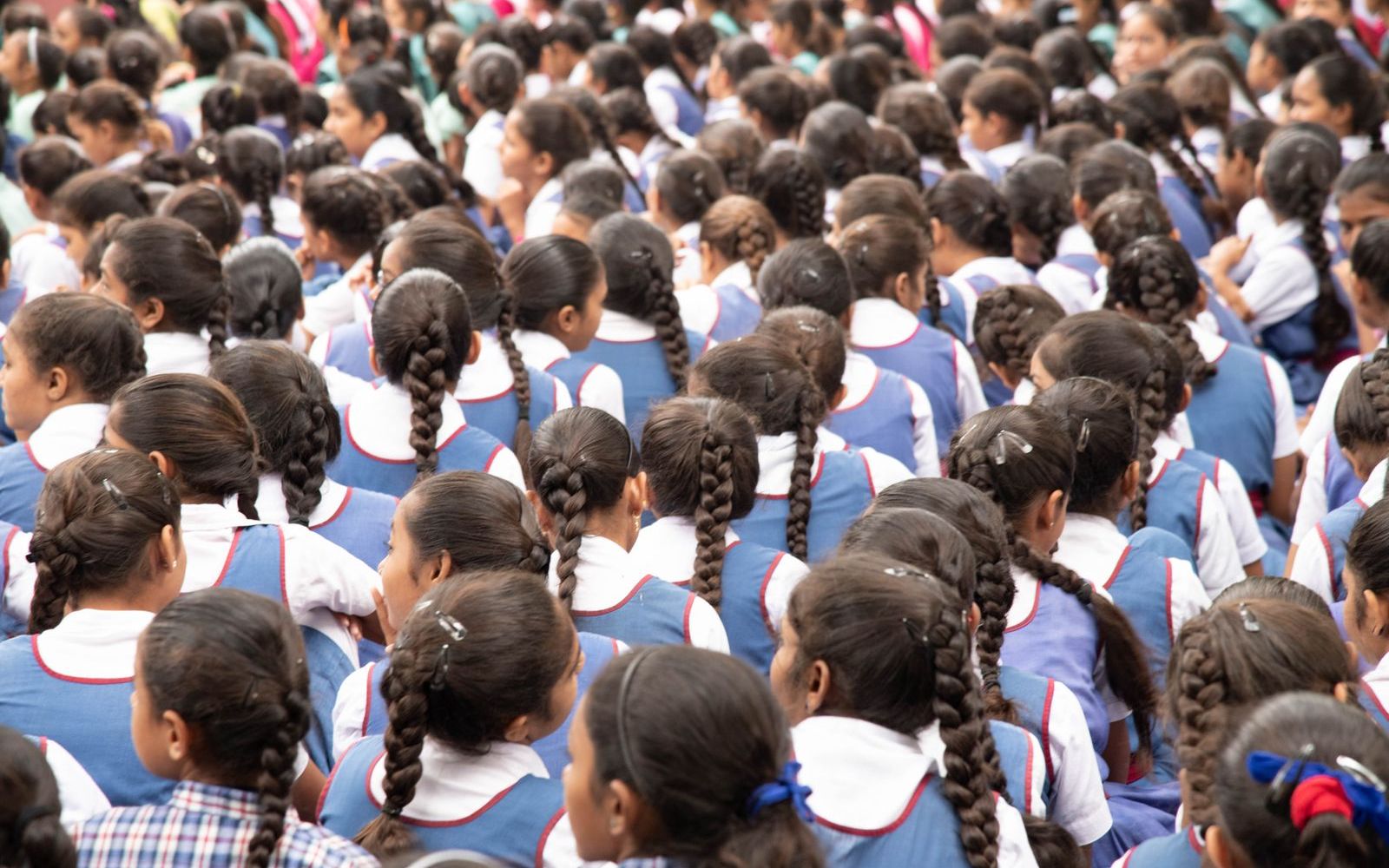 Rows of schoolgirls in uniform seated at a school assembly