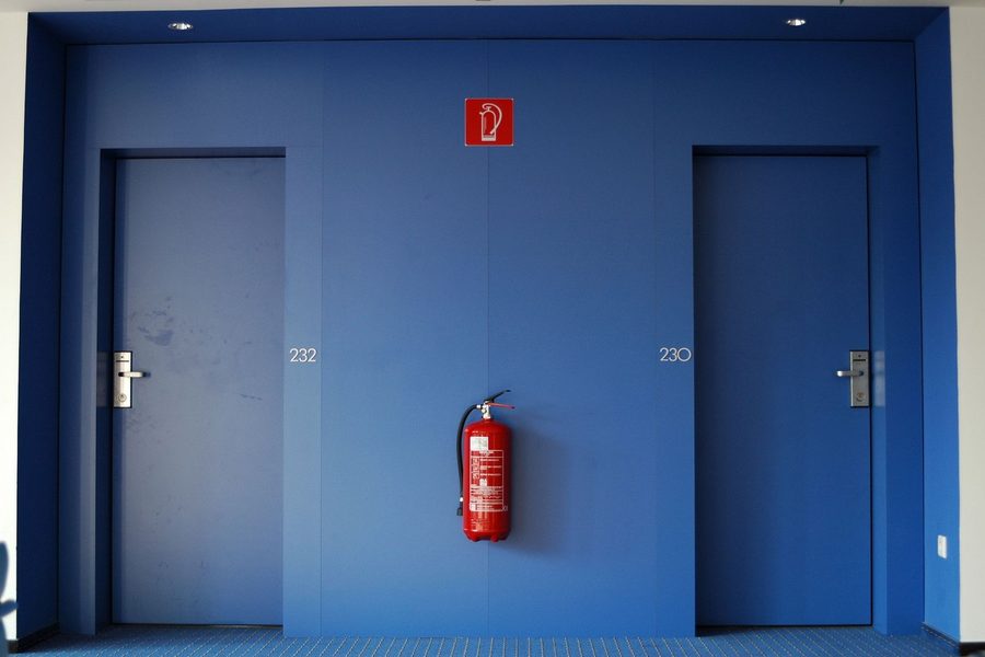 Corridor with blue doors and a wall-mounted fire extinguisher
