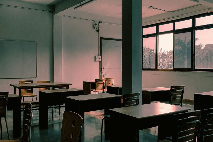 Empty Indian classroom with wooden desks in natural light